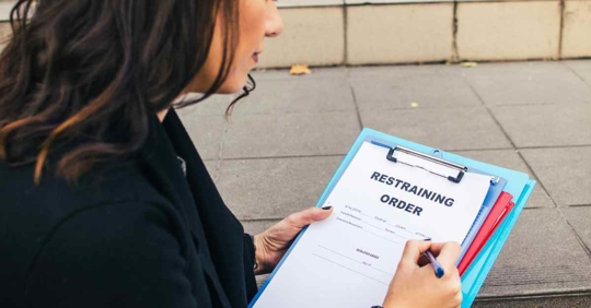 A woman filling out a restraining order