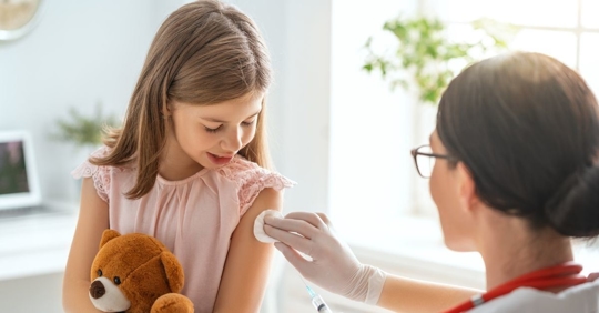 A young girl getting a vaccine at a doctor's office