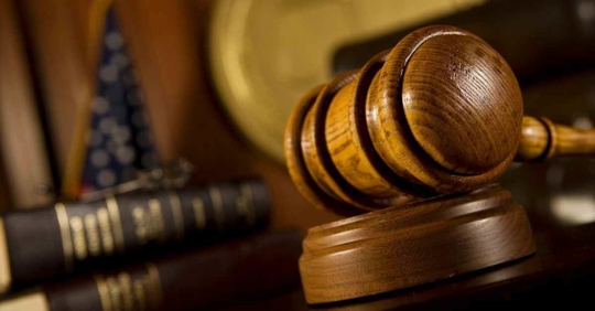 A gavel resting on a desk in a courtroom