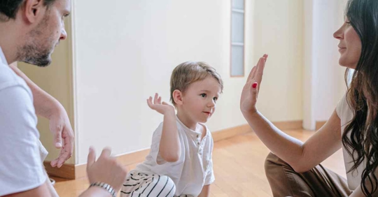 A child high-fiving his mother as his father sits nearby
