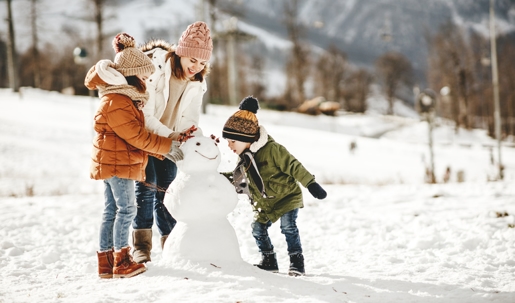 mother and children building a snowman
